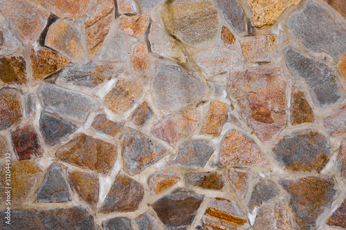 Texture of the wall made of granite stones. Construction, architecture, decoration.