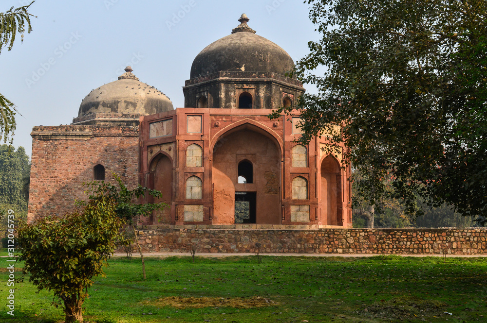 A monument at humayun tomb memorial from the side of the lawn at winter foggy morning.