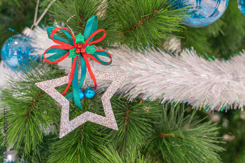 Beautiful Christmas star hanging from a decorated Christmas tree