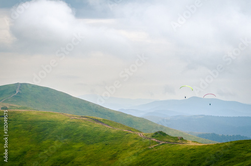 The top of the Carpathian mountains. Beautiful landscape with greenery and people paragliding. Rest and travel..