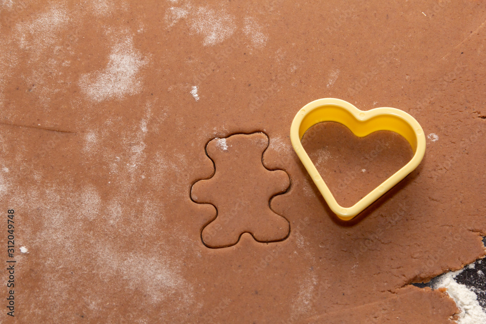 Cutting figures from the dough using special stencils for making ginger Christmas cookies. Home, family prepare for the holidays concept Cutting figures from the dough using special stencils for making ginger Christmas cookies. Home, family prepare for the holidays concept