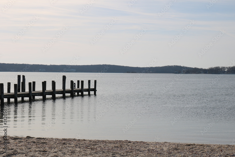 Obraz premium Old weathered wooden dock on a sandy coastal