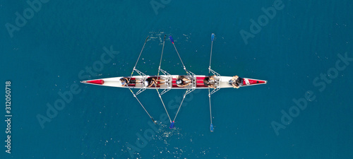 Aerial drone ultra wide photo of sport canoe with young team of athletes practising in deep blue open ocean sea