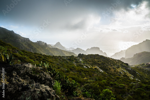 Bild auf Leinwand Spain, Tenerife, Dark rain storm clouds on stormy day with sun over mountains of