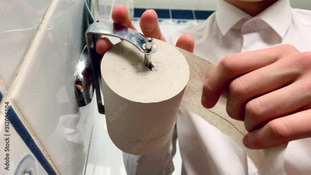 Man hand tears off a piece of toilet paper. Using toilet paper. Problem get rid of diarrhea