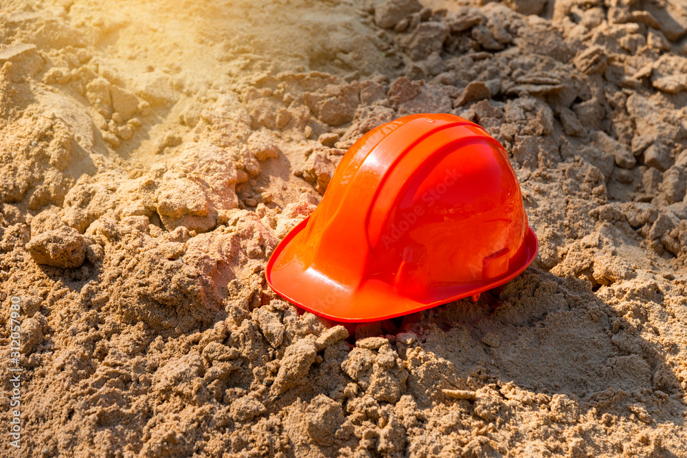 Orange Engineer hat on sand background. Orange Engineer hat on sand background.