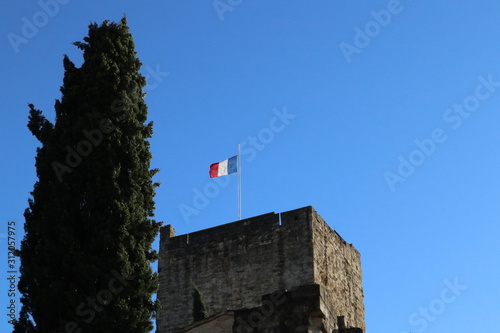 Flag of France in the wind on top of a castle tower