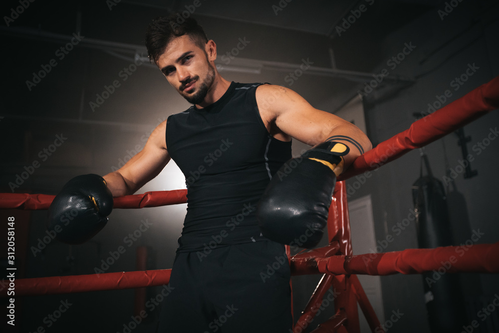 In a boxing ring athletic man have a break time after a boxing workout ...