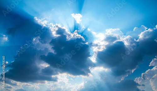 Fototapeta Naklejka Na Ścianę i Meble -  Rays of light with dramatic sky. Cumulus sunset dark clouds with sun setting down on dark background.Vivid orange and blue cloud sky.