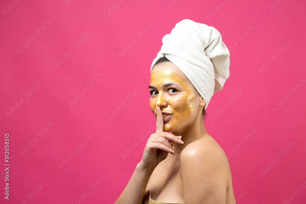 Beauty portrait of woman in white towel on head with gold nourishing mask on face. Skincare cleansing eco organic cosmetic spa relax concept. Beauty portrait of woman in white towel on head with gold nourishing mask on face. Skincare cleansing eco organic cosmetic spa relax concept.