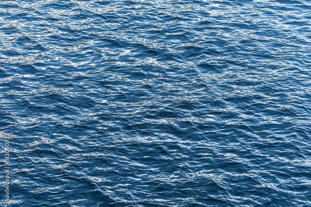 Obraz premium Blue water surface. Background texture photo of a water, river or sea. Clear wawing water surface.
