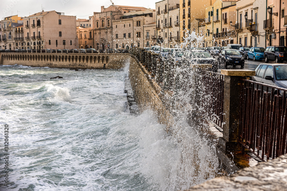 sea waves crashing against the city wall
