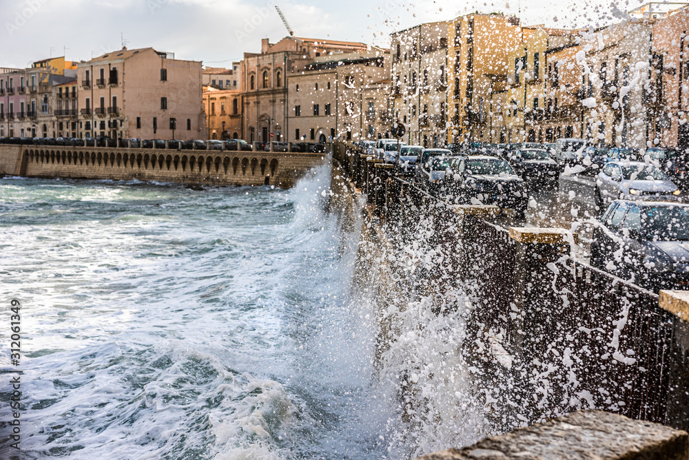 sea waves crashing against the city wall