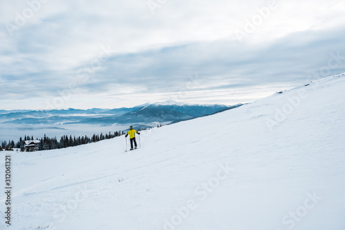 skier holding ski sticks while sporting in wintertime