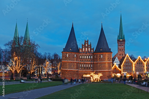 Blick auf die Altstadt von Lübeck mit dem Holstentor, der Marienkirche (links), der Petrikirche und historischen Salzspeichern zu Weihnachten