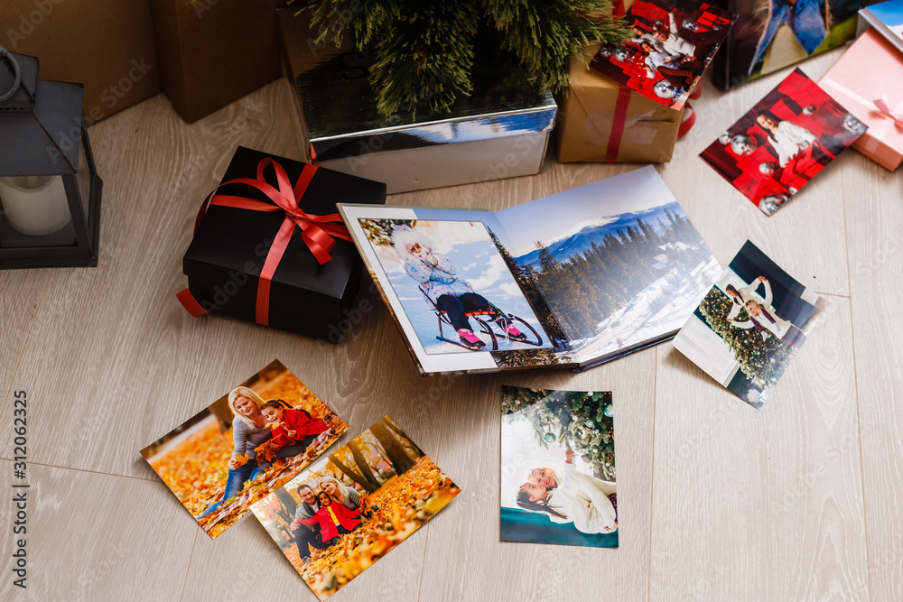 Fototapeta premium New Year celebrating. Photobook with photos of summer travel under the Christmas tree