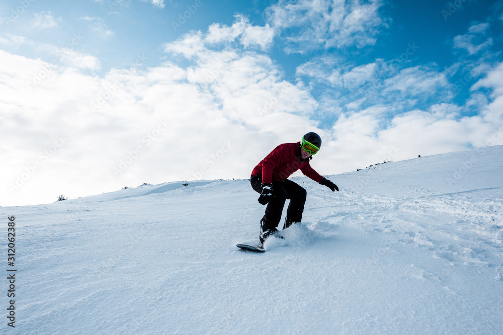 sportive snowboarder riding on slope with white snow in wintertime sportive snowboarder riding on slope with white snow in wintertime