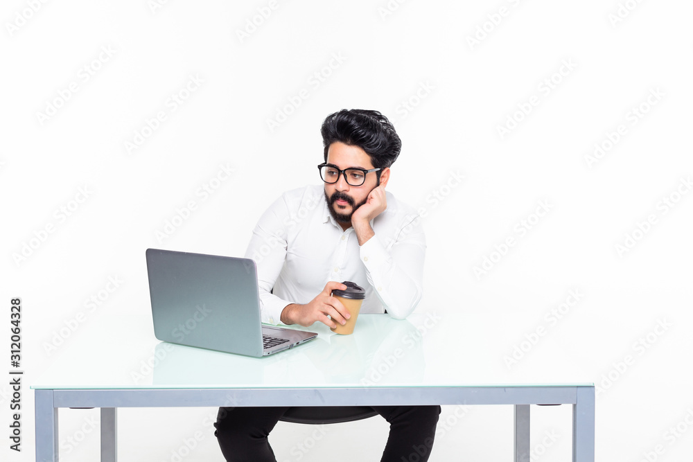 Handsome bearded businessman using a laptop and taking notes while sitting in cafe isolated on white background Handsome bearded businessman using a laptop and taking notes while sitting in cafe isolated on white background