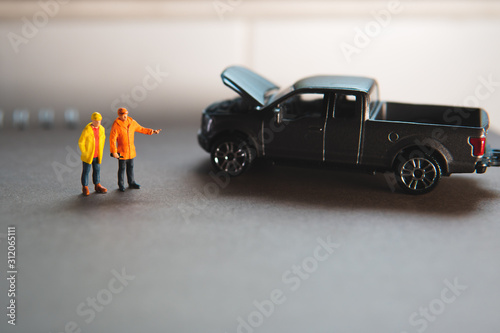 Miniature people, car mechanic standing with breakdown pickup truck using as the automotive concept