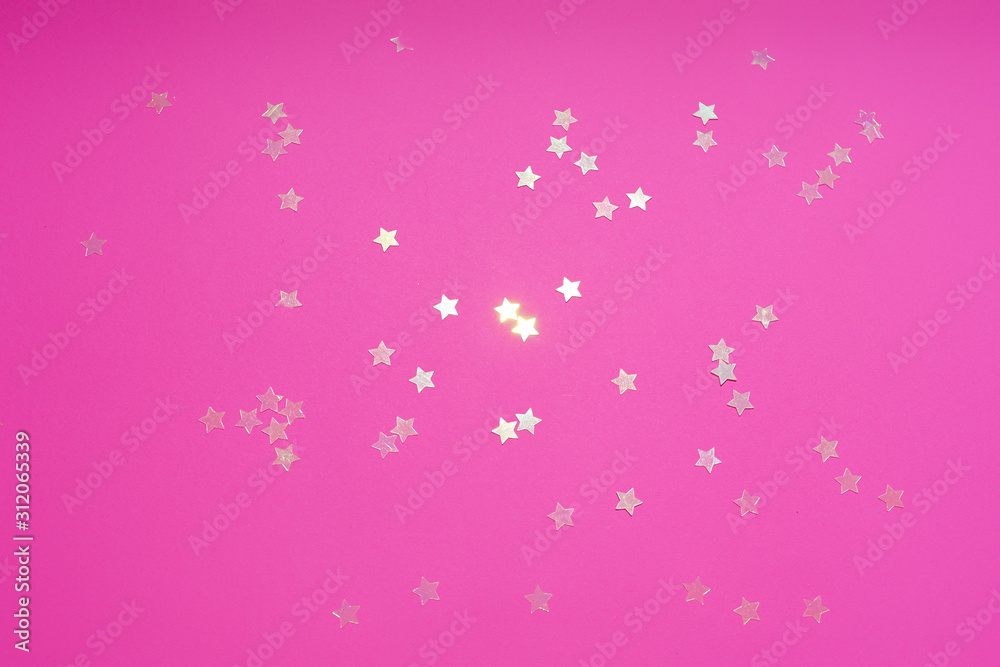 Flatlay with star-shaped glimmering sequins on pink background. Festive party concept Flatlay with star-shaped glimmering sequins on pink background. Festive party concept