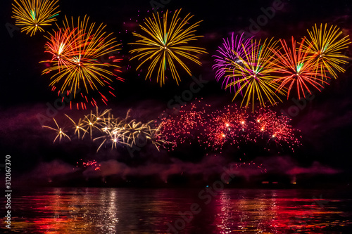 Bright festive fireworks reflected in the river © LightOffDark