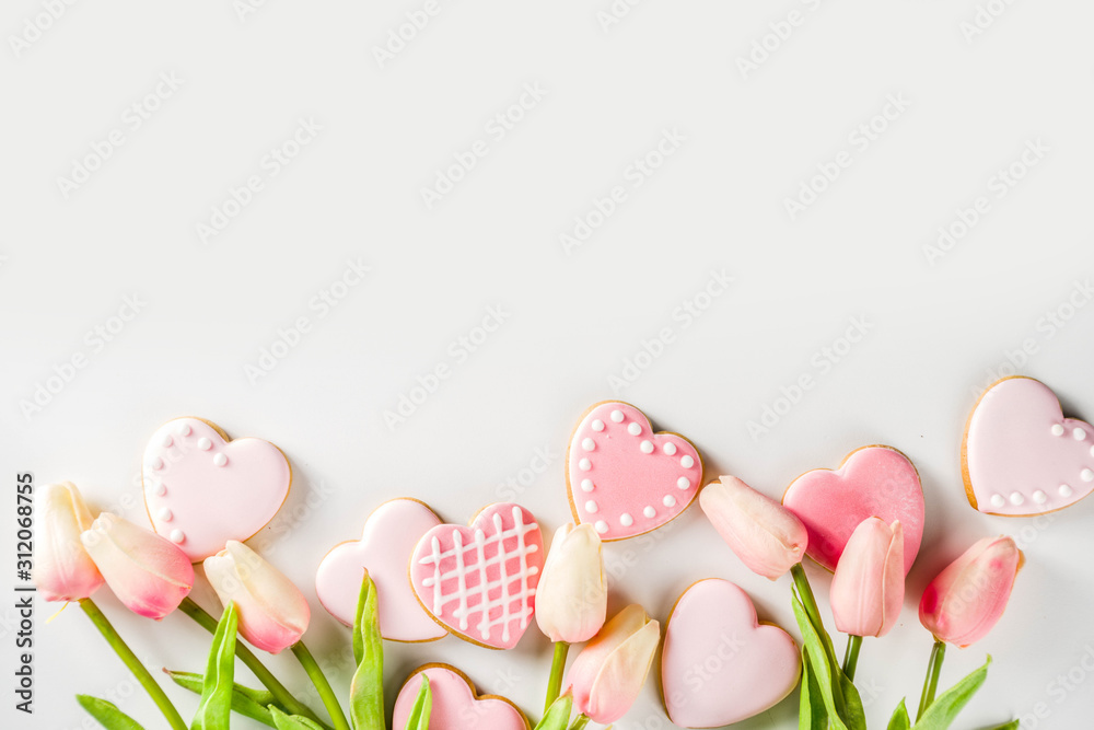 Homemade pick sugar glazed Valentine day cookies. Valentine heart shaped bakings. White stone background copy space top view