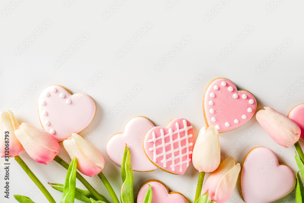 Homemade pick sugar glazed Valentine day cookies. Valentine heart shaped bakings. White stone background copy space top view Homemade pick sugar glazed Valentine day cookies. Valentine heart shaped bakings. White stone background copy space top view