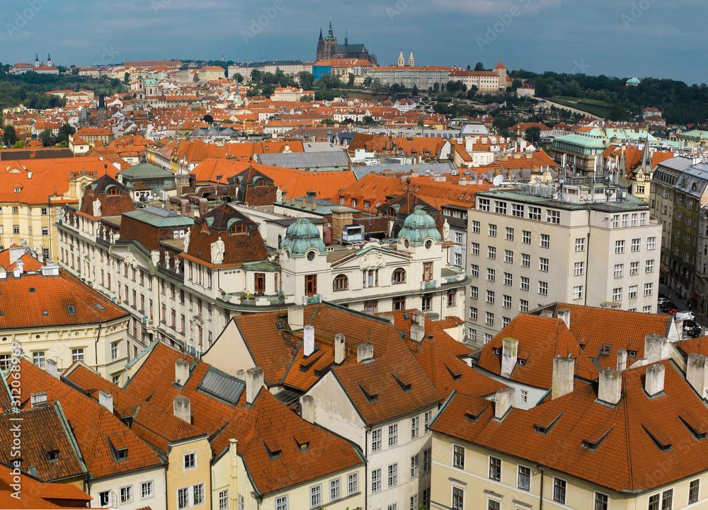 view of the red roofs of Mala Strana and St. Vitus Cathedral in Prague, Czech Republic.
