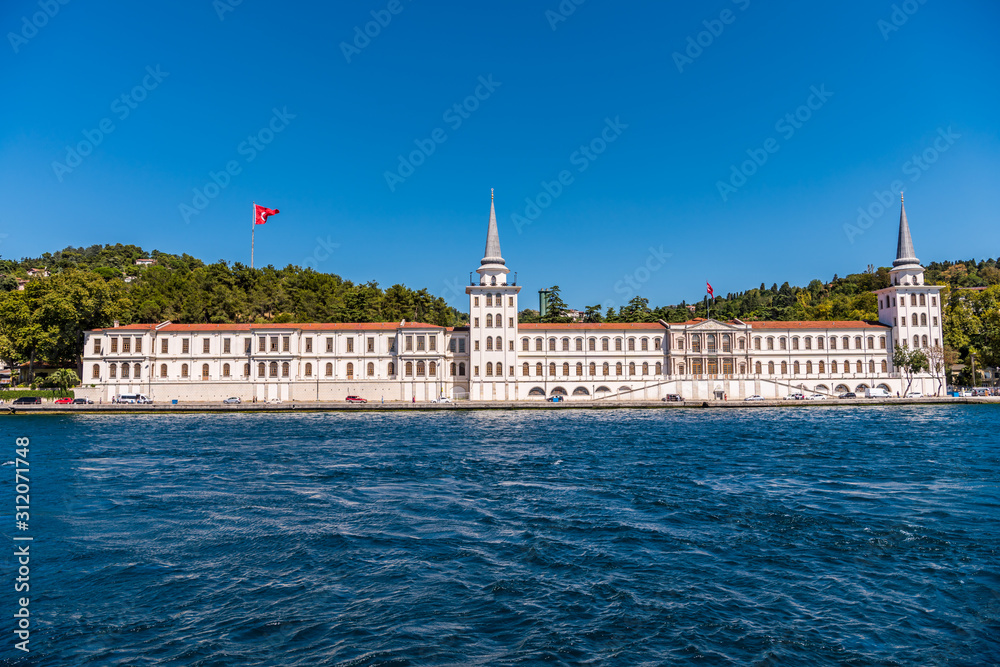 Kuleli Military High School building with tower and flags of Turkey on seashore of Bosphorus strait, Istanbul, Turkey.