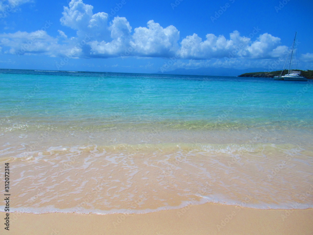 Une plage de sable blanc devant la mer turquoise