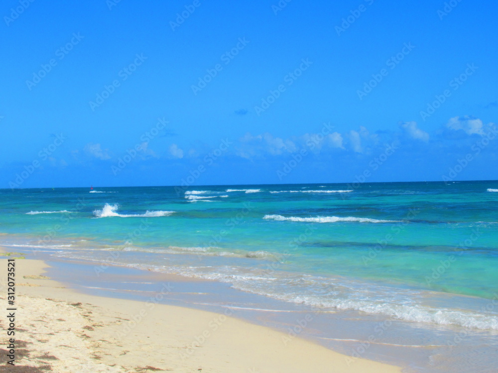 Une plage de sable blanc devant la mer turquoise avec des vagues Une plage de sable blanc devant la mer turquoise avec des vagues