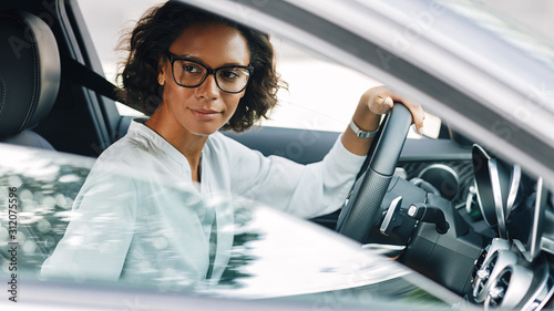 Young female entrepreneur driving a car looking away photo