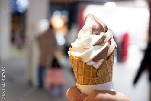 Fotografie Hand Holding a vanilla and chocolate soft serve ice cream cone