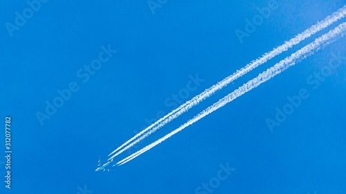 Four engined airplane during flight in high altitude with condensation trails