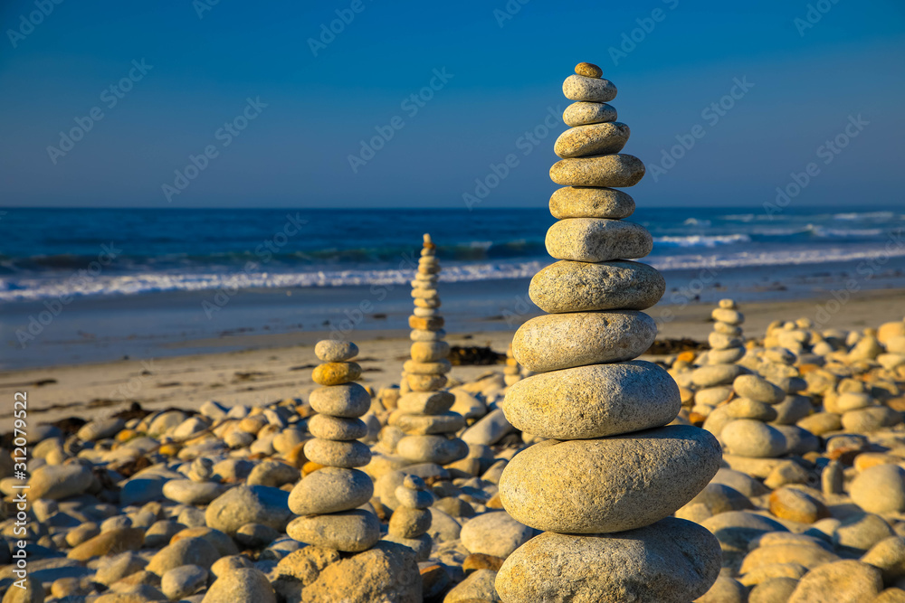 Fototapeta premium Pyramid of stones on the sea and sky background