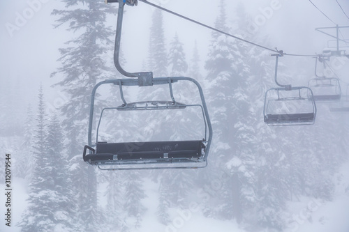 Whistler, British Columbia, Canada. Ski Lift Chairs on the Mountain during a cloudy and foggy winter day.