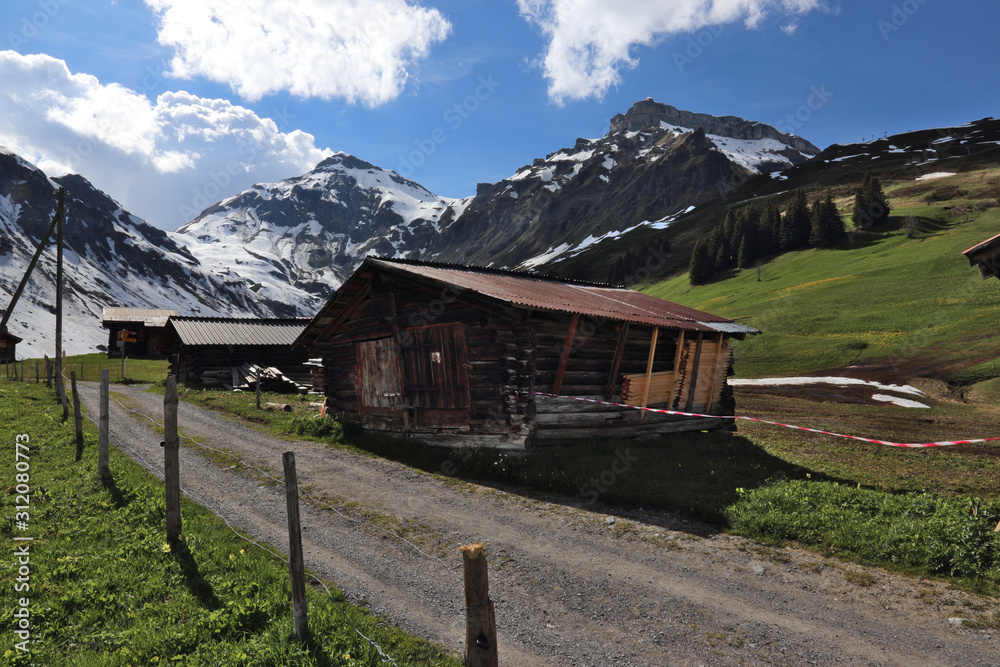 Cottages on the outskirts of Murren, Switzerland with the Bernese Alps in the background.