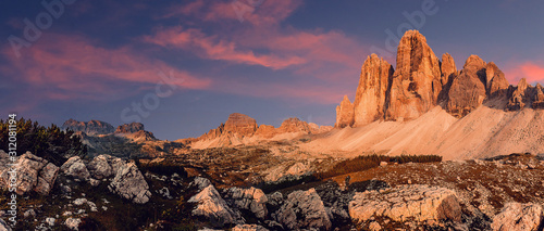 Awesome alpine highlands during Sunset. Amasing nature landscape. Tre Cime di Laveredo, three spectacular mountain peaks with colorful sky, Dolomites Alps, South Tyrol, Italy. Picture of wild area