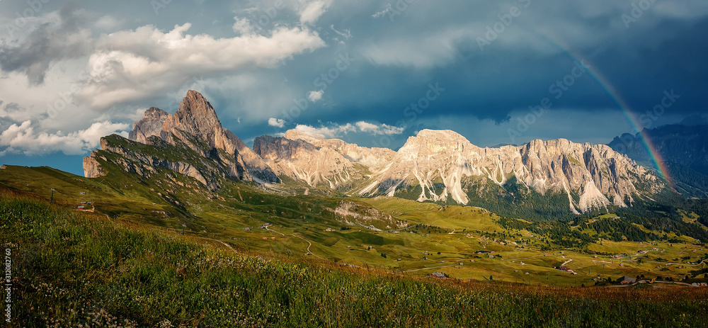 The rainbow over the seceda ridge, idyllic mountain scenery in the Dolomites Alps with Majestic Peaks, Overcast sky and Rainbow. Odle mountain range, Val Gardena in Dolomites. Italy. Amazing Nature