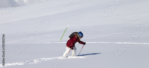 Little skier on off-piste slope with new fallen snow at sun day