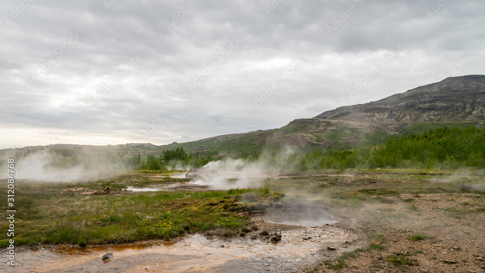 Geothermal area of Strokkur in Iceland with hot boiling thermal water