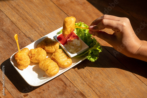 Eating chicken nuggets with two dipping sauce.