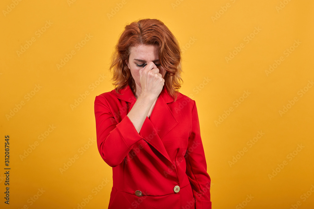 Attractive caucasian young woman wearing fashion red jacket over isolated orange background covered nose with hands, bad smell. People lifestyle concept. Attractive caucasian young woman wearing fashion red jacket over isolated orange background covered nose with hands, bad smell. People lifestyle concept.