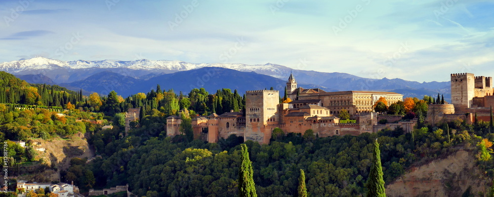 im Abendlicht erstrahlte Alhambra in Panoramaansicht vor schneebedeckter Sierra Nevada