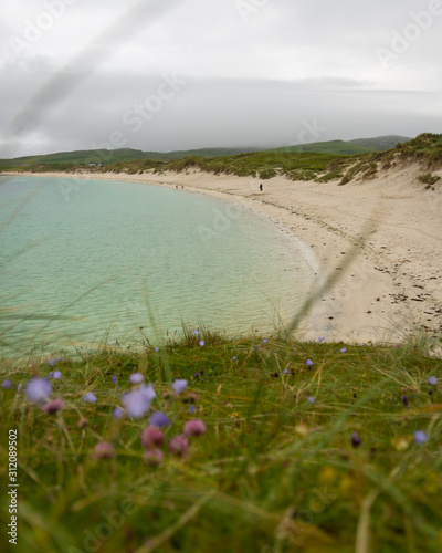 beach and sea with machair in foreground, vatersay, outer hebrides photo