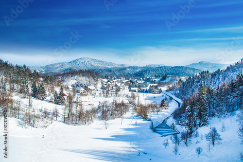 Winter in Croatia, Countryside landscape in winter, panoramic view of small town of Lokve under snow in Gorski kotar photo