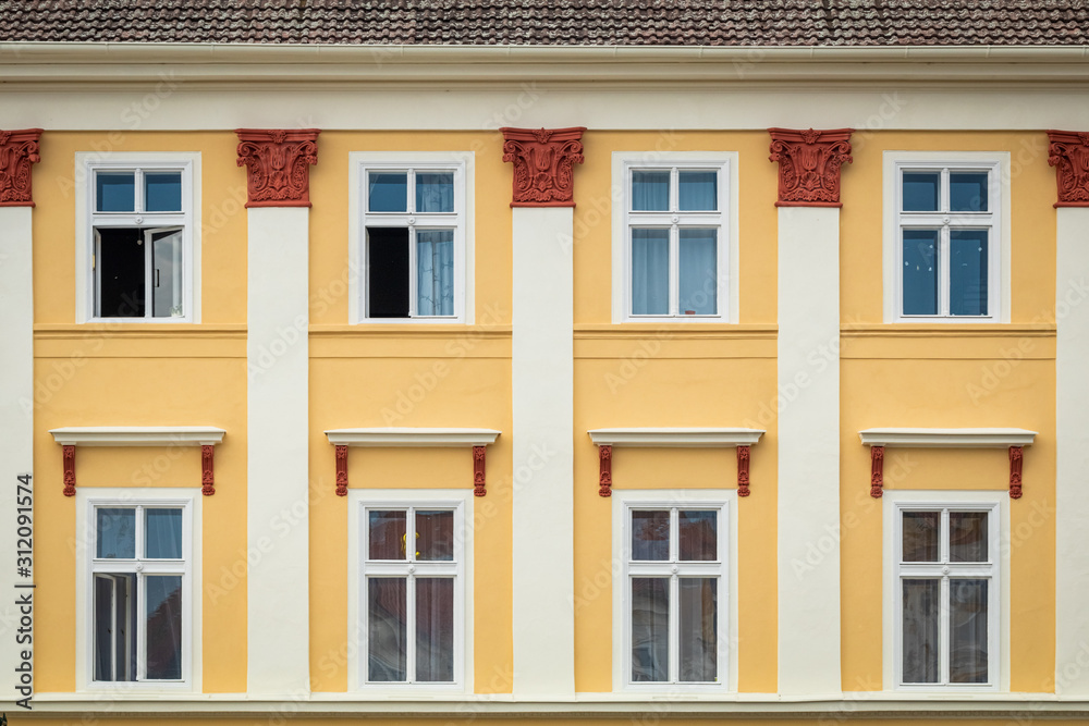 Yellow facade of the old house. The Windows and decoration of walls in Litomerice, Czechia