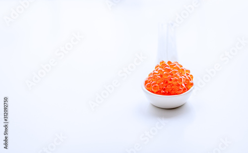 Closeup of red salmon caviar in a light blurry spoon. Copy space.