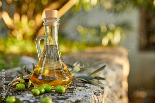 olive oil with fresh olives and leaves