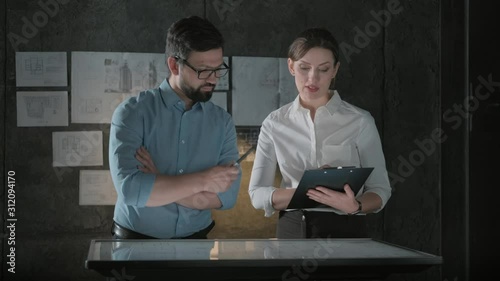 Colleagues work in a dark office in front of an interactive display